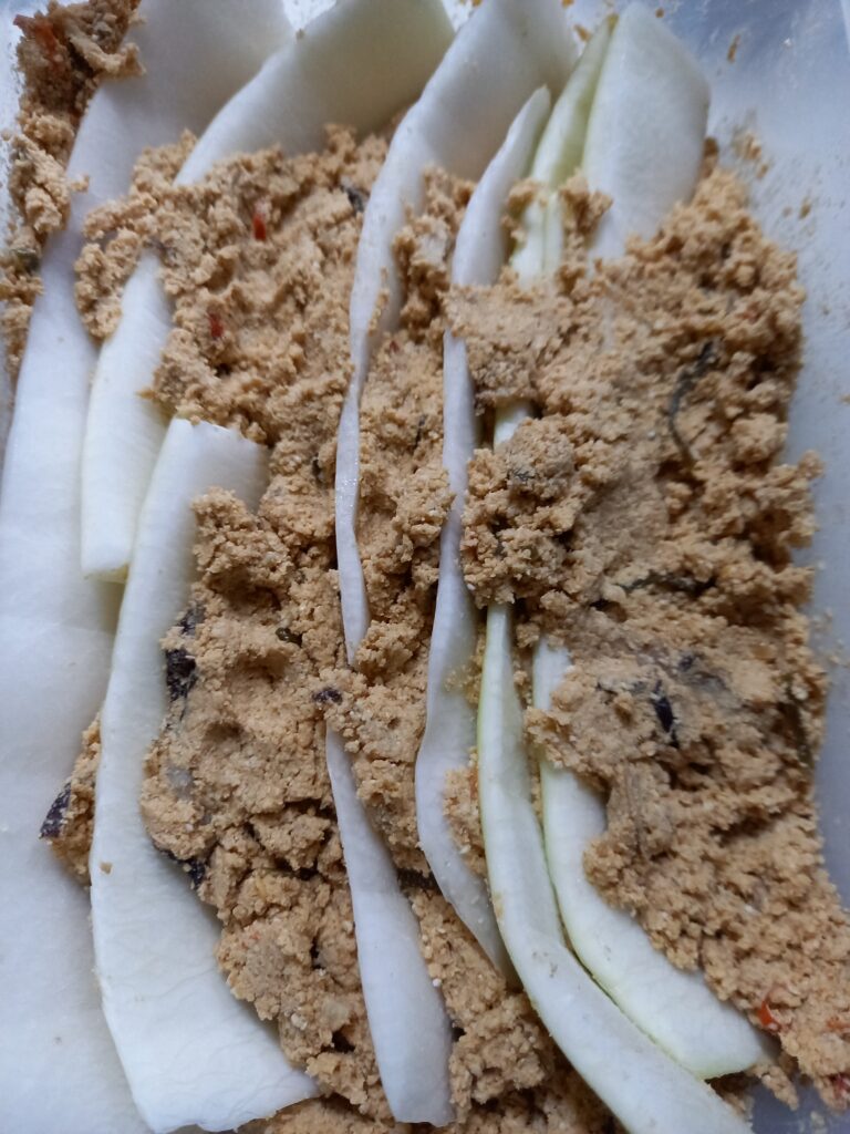 厚めに切った大根の皮をぬか床に入れている様子